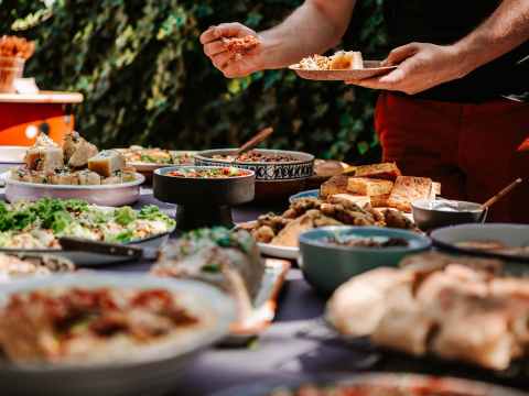 man filling his plate with food from buffet table