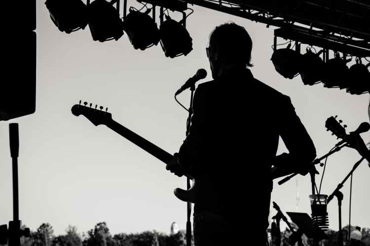 silhouette photo of man holding guitar