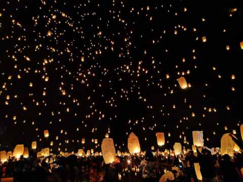 group of people throwing paper lantern on sky during night